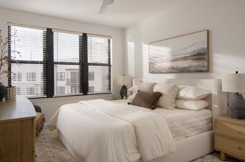 A bedroom with a large bed and a painting on the wall